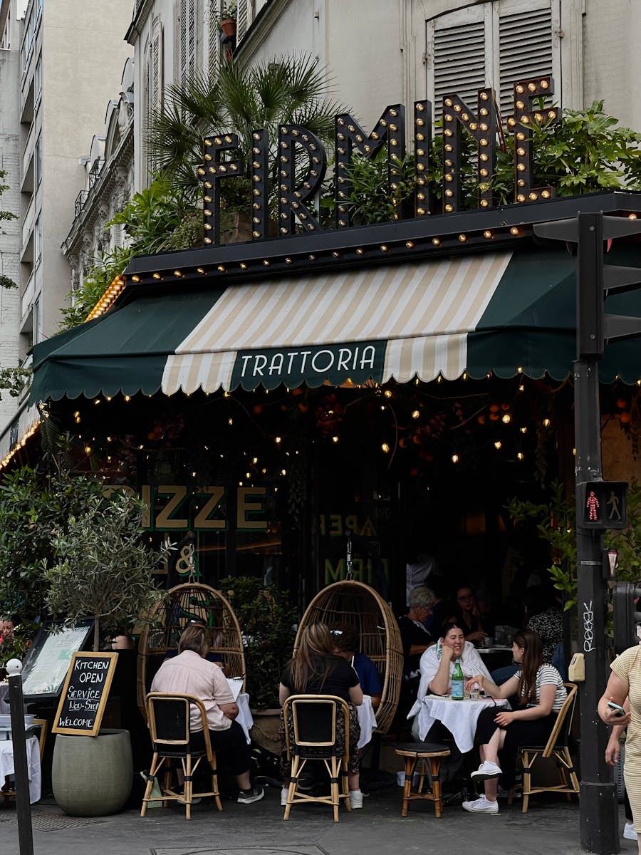 Photo by Antonina Blakytna Enjoy a cozy dining experience at a trattoria with lush plants and intimate seating.